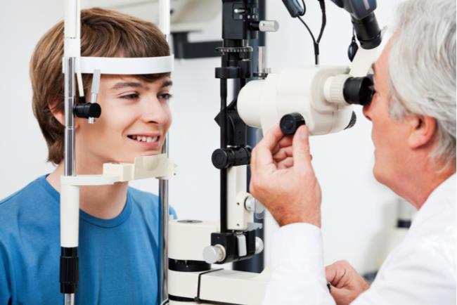 רואה עיניים מבצע בדיקת ראייה למתבגר כדי לאבחן קורטוקונוס 